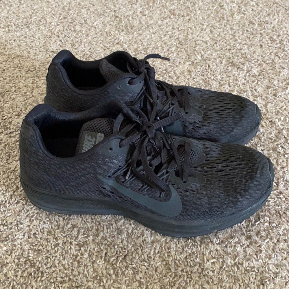 Solid black Nike zoom tennis shoe.